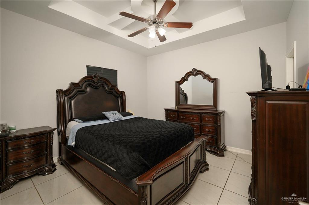 473 Pera Avenue Brownsville, TX 78521 - Photo 8 of 17 a bedroom with a bed and a chandelier