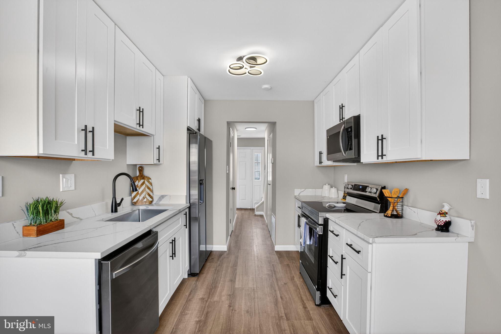 3278 Ryon Court Waldorf, MD 20601 - Photo 8 of 29 a kitchen with stainless steel appliances granite countertop a refrigerator a stove a sink dishwasher and white cabinets with wooden floor