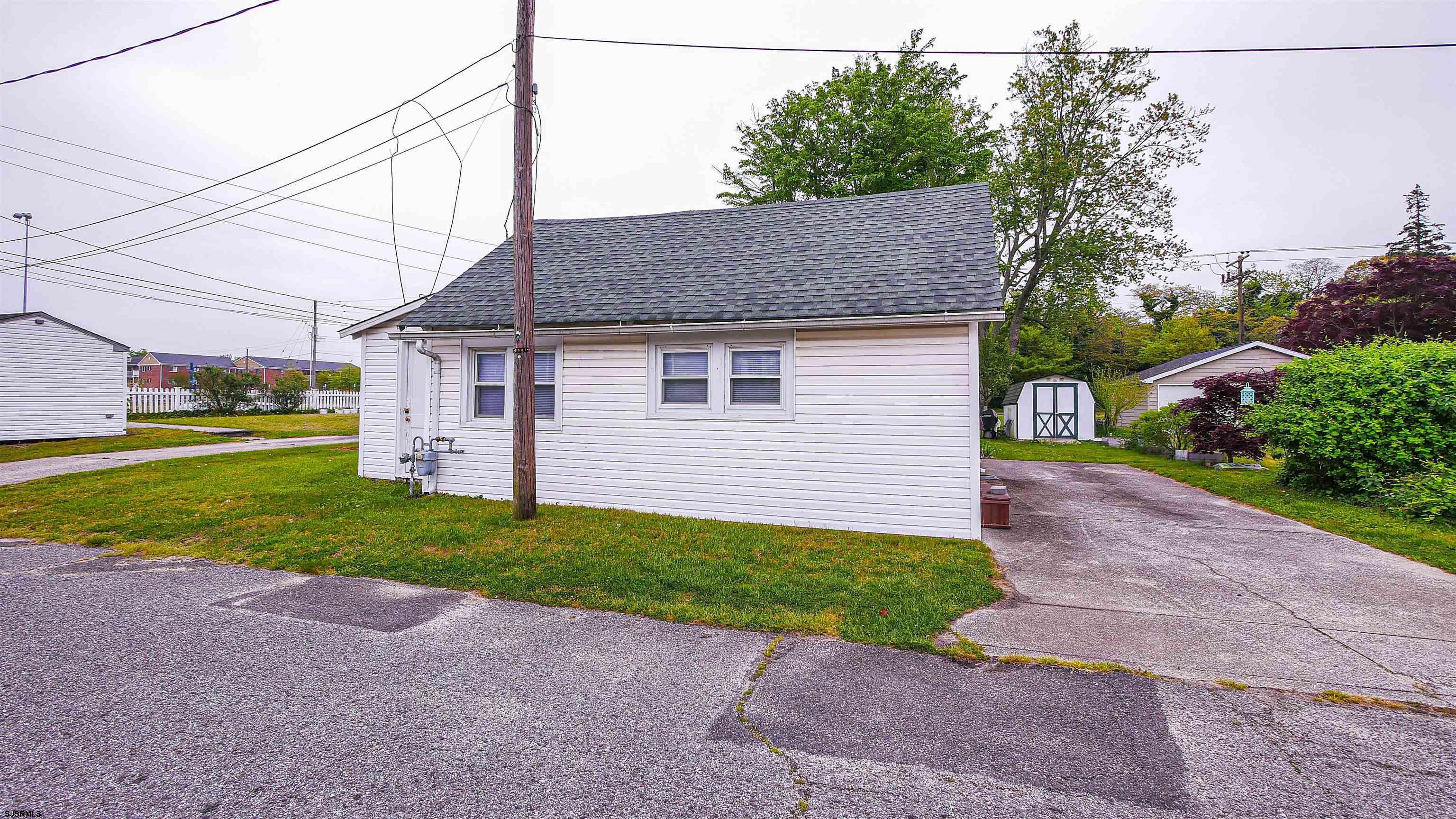 605 1st Street Somers Point, NJ 08244 - Photo 14 of 33 a front view of a house with a yard and garage