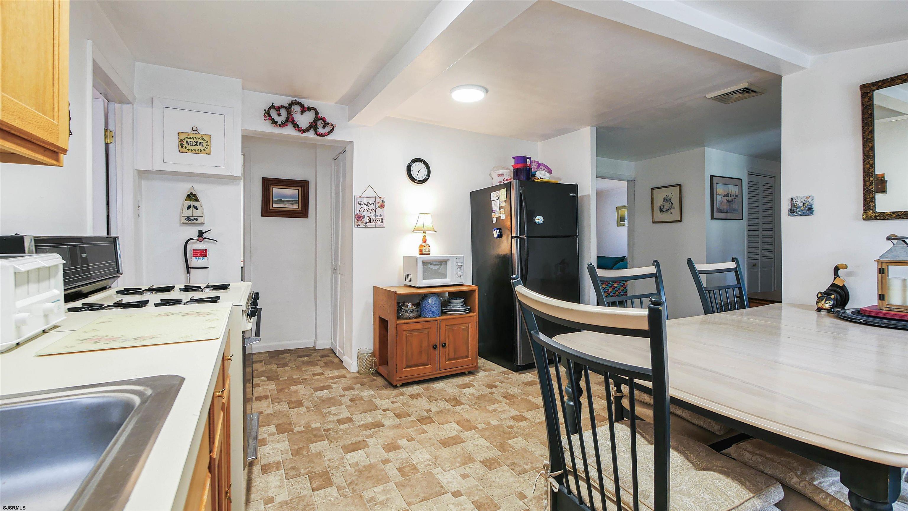 605 1st Street Somers Point, NJ 08244 - Photo 25 of 33 a kitchen that has a refrigerator a stove a dining table and chairs with wooden floor
