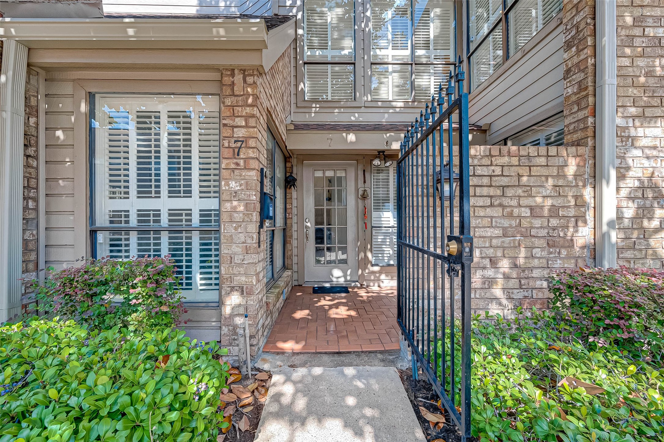 1908 Augusta Drive, Unit 7 Houston, TX 77057 - Photo 1 of 33 a view of a brick house with a large windows and plants