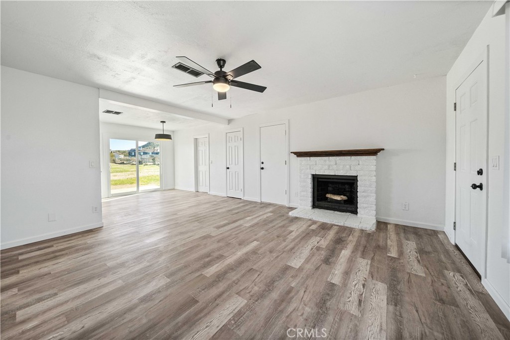 40054 Ridgemist Street Palmdale, CA 93591 - Photo 5 of 21 a view of empty room with wooden floor and fireplace