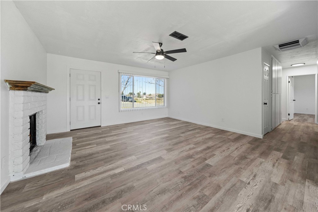 40054 Ridgemist Street Palmdale, CA 93591 - Photo 6 of 21 wooden floor in an empty room with a fireplace