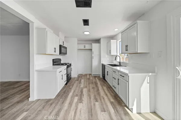 a kitchen with granite countertop a sink stove and refrigerator