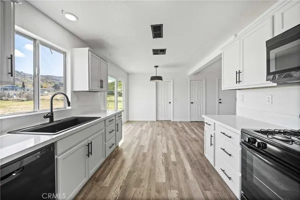 a kitchen with granite countertop a sink stove and cabinets