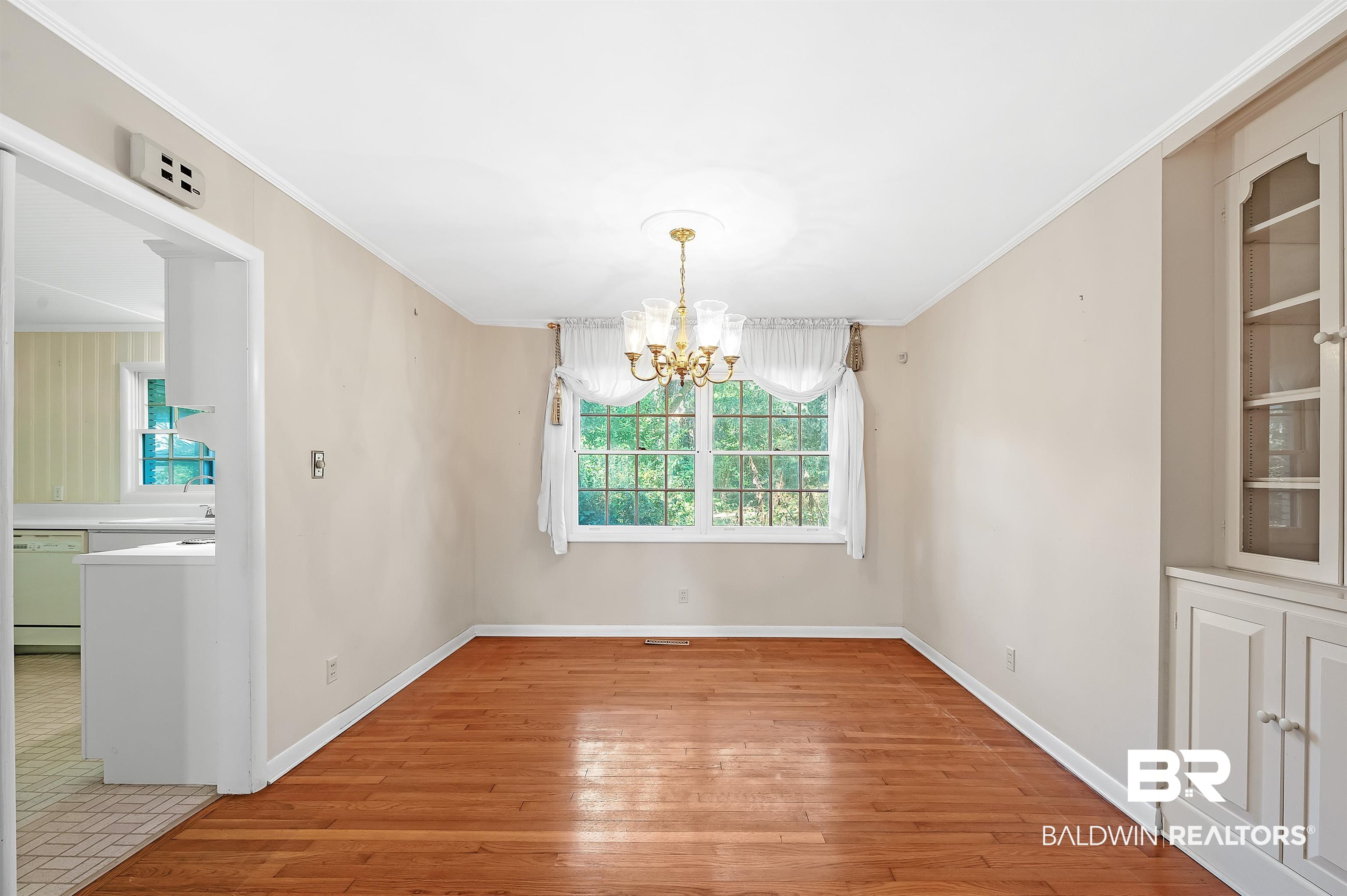 14375 Oak Street Magnolia Springs, AL 36555 - Photo 8 of 20 Unfurnished dining area with ornamental molding, oak hardwood floors, and a notable chandelier