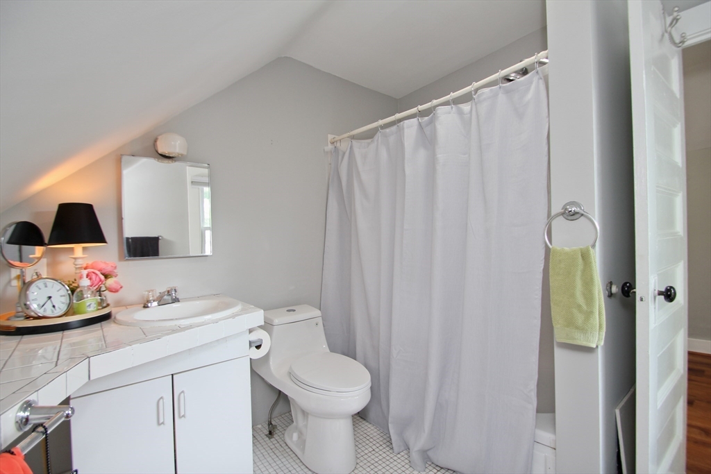 38 Virginia Street Springfield, MA 01108 - Photo 29 of 42 a bathroom with a sink a toilet and shower curtain