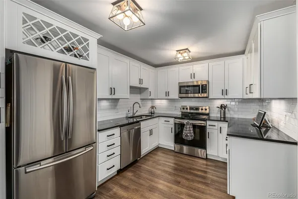 a kitchen with stainless steel appliances a refrigerator sink and microwave