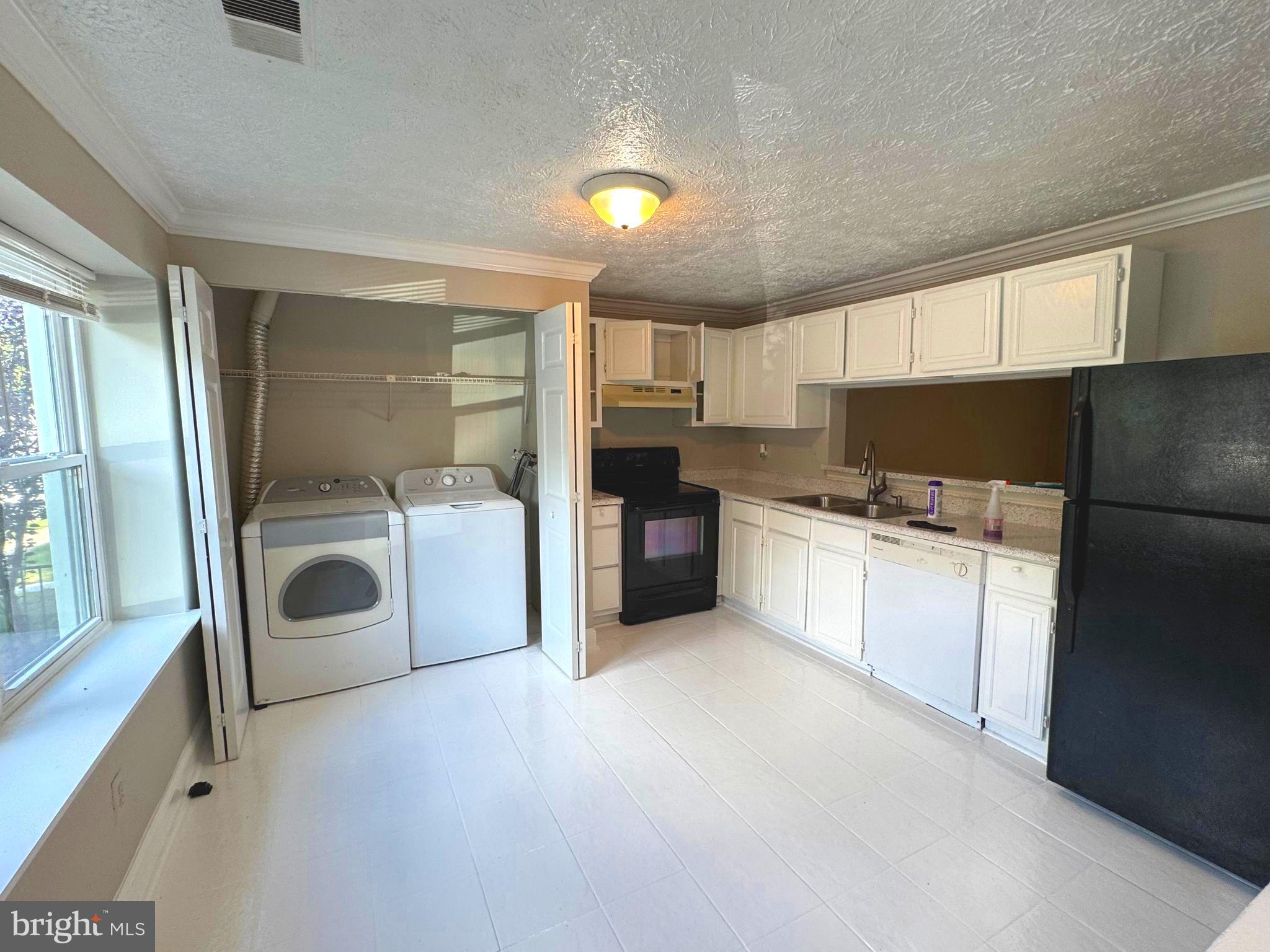 3615 Wharf Lane Triangle, VA 22172 - Photo 6 of 23 a kitchen with a refrigerator and white cabinets