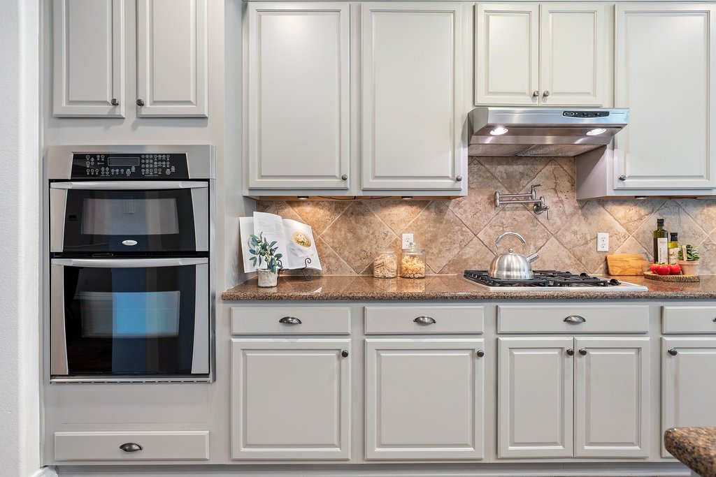 11129 Bastogne Loop Austin, TX 78739 - Photo 13 of 40 Built-in ovens, gas cooking, and expansive prep space make this kitchen as functional as it is beautiful.