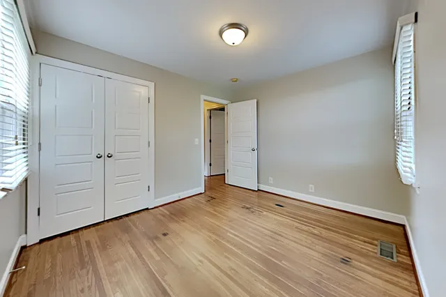 an empty room with wooden floor and closet