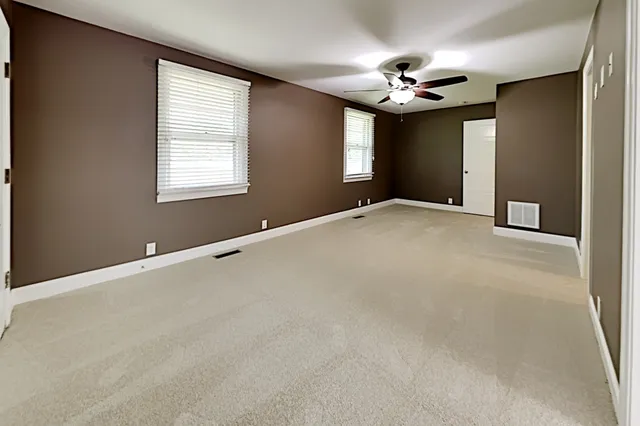 a view of a livingroom with a ceiling fan and window