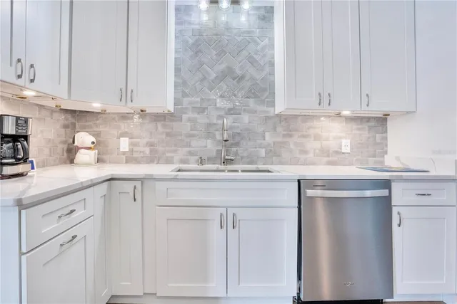 a kitchen with white cabinets and white appliances