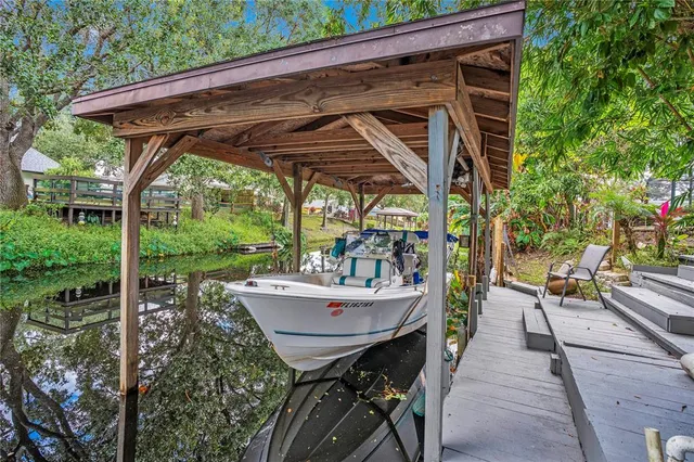 a view of patio with table and chairs potted plants with wooden floor and fence