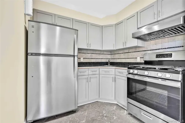 a kitchen with a stove refrigerator and microwave