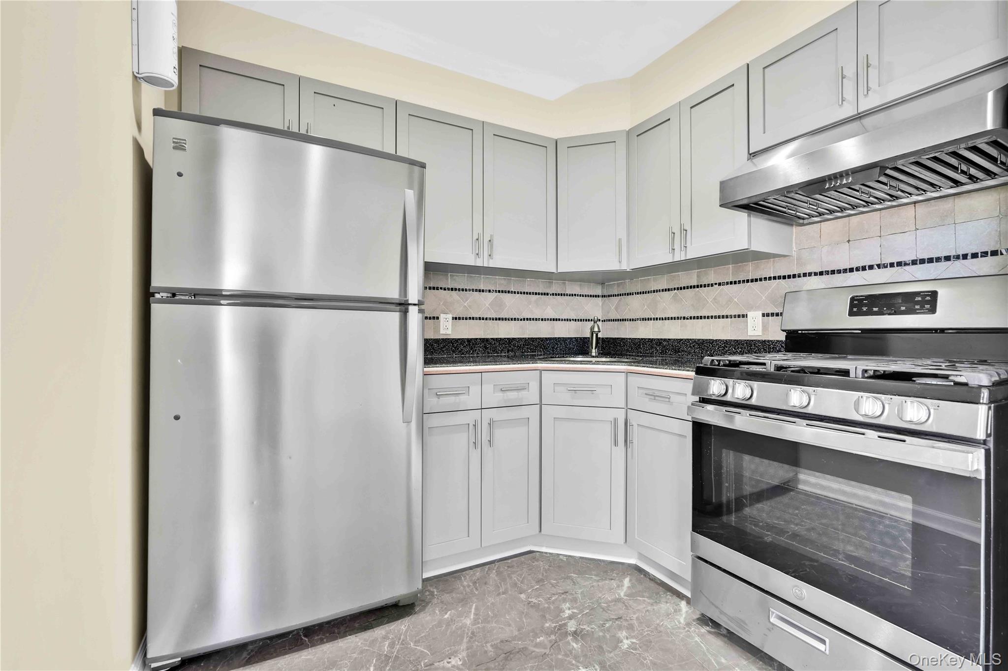 88-20 70th Road Queens, NY 11375 - Photo 11 of 30 a white refrigerator freezer and a stove sitting inside of a kitchen
