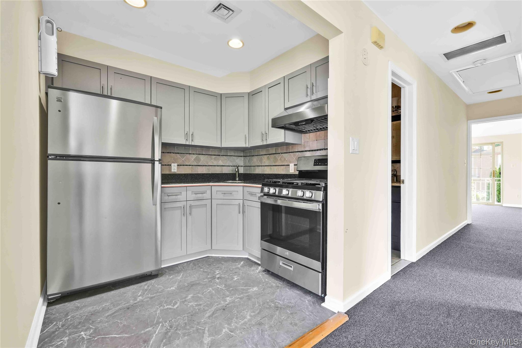 88-20 70th Road Queens, NY 11375 - Photo 11 of 31 a kitchen with cabinets and white stainless steel appliances