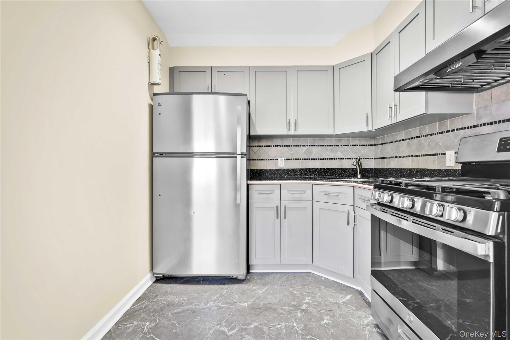 88-20 70th Road Queens, NY 11375 - Photo 12 of 30 a kitchen with a stove refrigerator and microwave