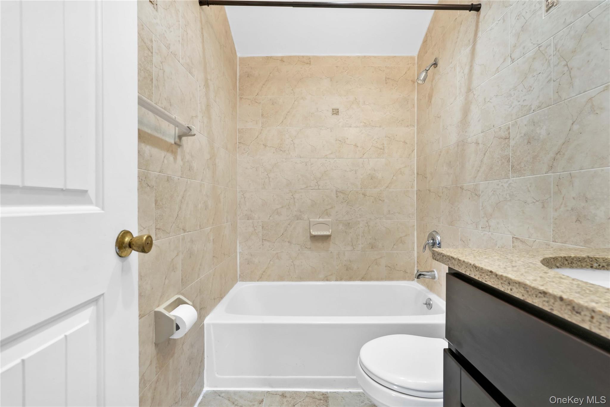 88-20 70th Road Queens, NY 11375 - Photo 22 of 30 a bathroom with a granite countertop bathtub shower sink vanity and toilet