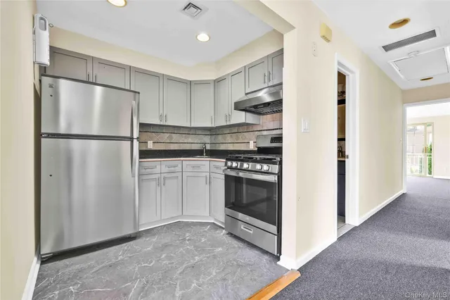 a white refrigerator freezer and a stove sitting inside of a kitchen