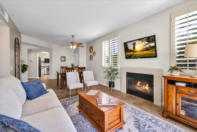 a living room with furniture a flat screen tv and a fireplace
