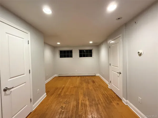 a view of a big room with wooden floor and windows
