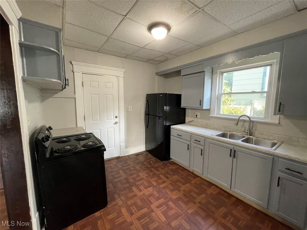 950 Avon Street Akron, OH 44310 - Photo 6 of 15 Kitchen with light countertops, a sink, black appliances, and open shelves