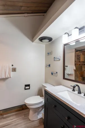 a bathroom with a granite countertop sink a toilet and a mirror