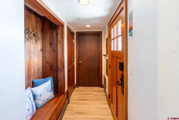a view of a hallway with wooden floor and staircase