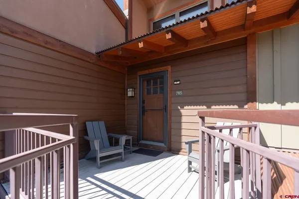 a porch with seating space and wooden fence