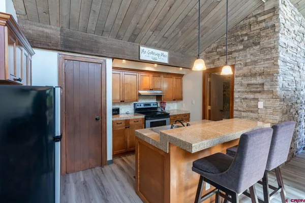 a kitchen with stainless steel appliances granite countertop a table chairs and a refrigerator