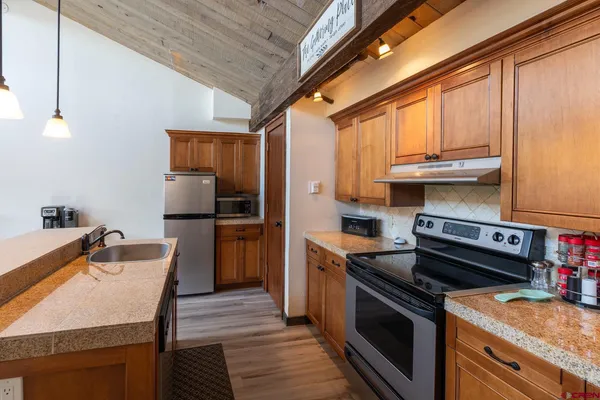 a kitchen with stainless steel appliances granite countertop a stove a sink and a refrigerator