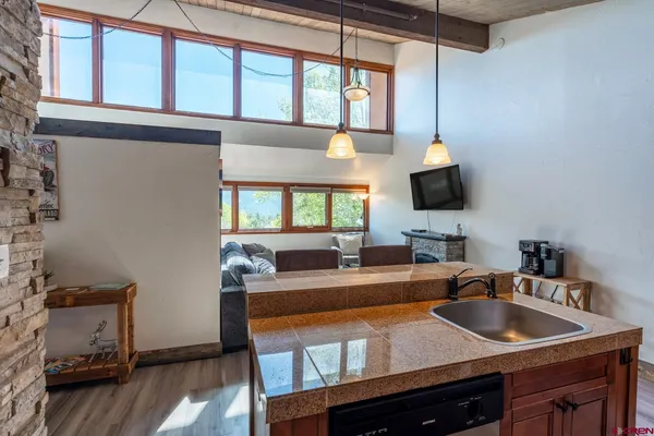 a kitchen with a sink cabinets and a flat screen tv