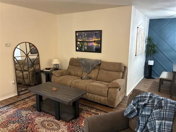a living room with a couch and a stove with wooden floor