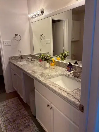 a bathroom with a granite countertop sink double and mirror