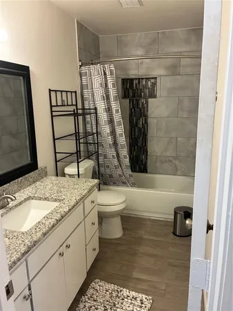 a bathroom with a granite countertop sink toilet and shower