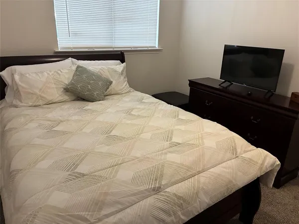 a bedroom with a bed and flat screen tv