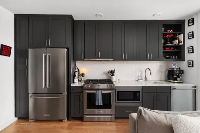 a kitchen with stainless steel appliances granite countertop a refrigerator stove and sink