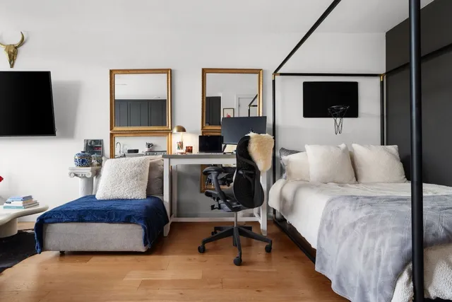 a bedroom with a bed and a flat screen tv