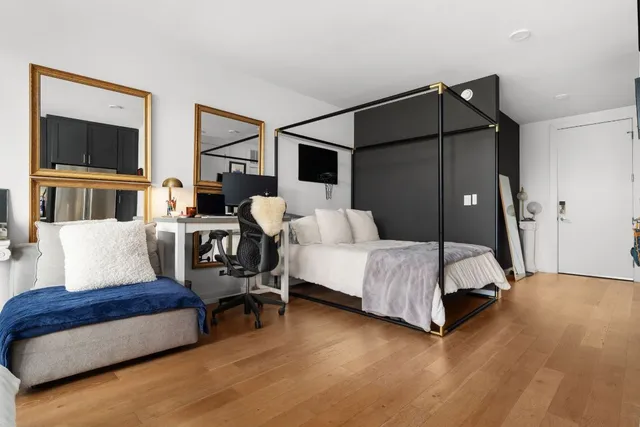 a spacious bedroom with a bed and a flat screen tv