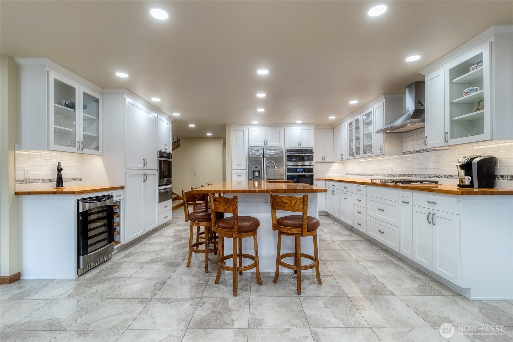 1343 Highland Road Walla Walla, WA 99362 - Photo 10 of 40 a large kitchen with kitchen island a dining table chairs and white cabinets