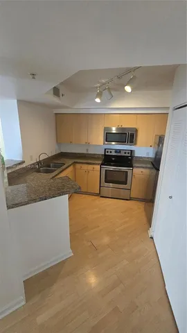 a kitchen with stainless steel appliances granite countertop a sink and stove top oven