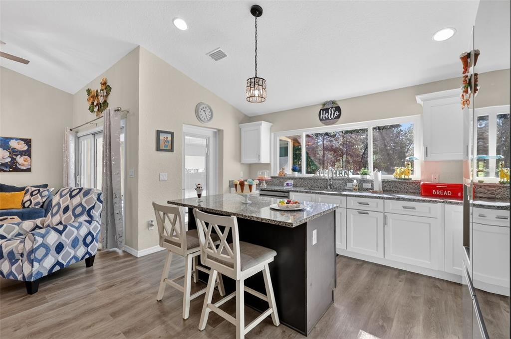 18168 Southwest 65th Loop Dunnellon, FL 34432 - Photo 11 of 26 a kitchen with stainless steel appliances kitchen island granite countertop a table and chairs in it