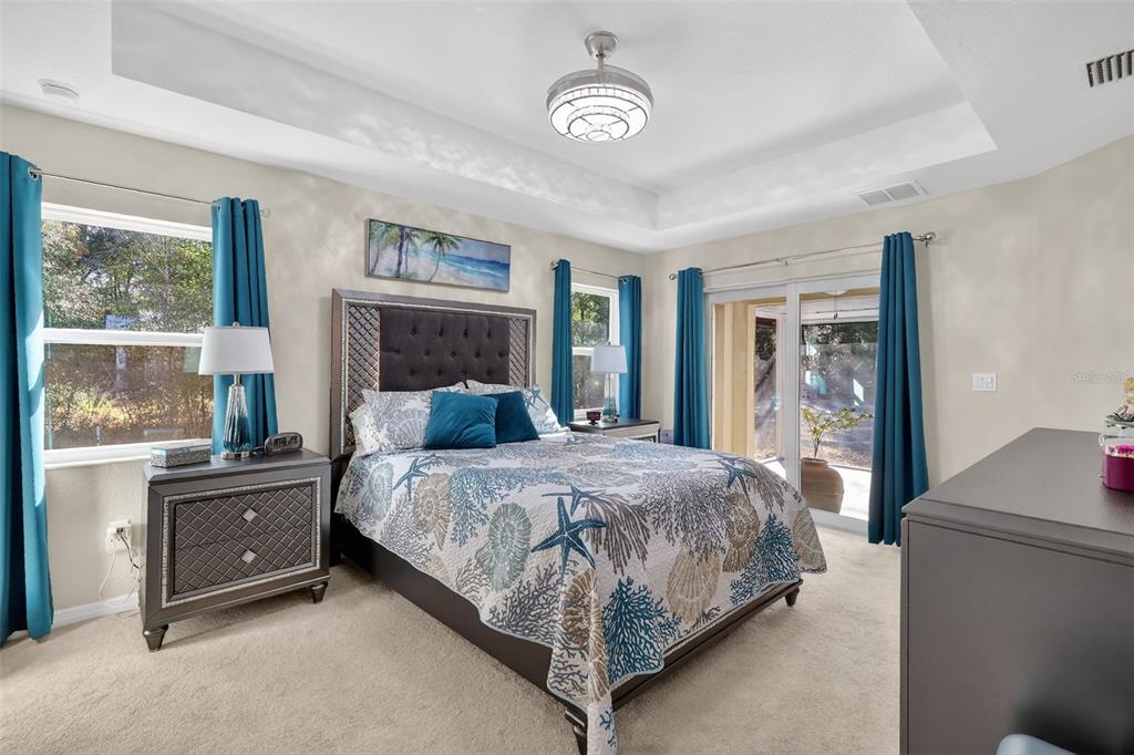 18168 Southwest 65th Loop Dunnellon, FL 34432 - Photo 14 of 26 a bedroom with a large bed and a chandelier