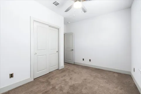 an empty room with a ceiling fan and a window