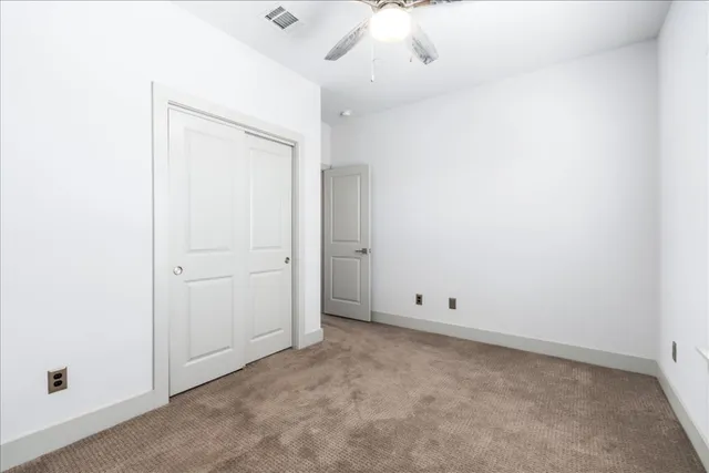 an empty room with a ceiling fan and a window
