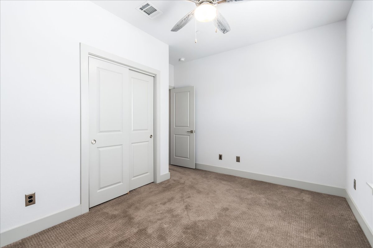 2021 Local Rebel Street, Unit 2021 Leander, TX 78641 - Photo 17 of 40 Unfurnished bedroom with carpet flooring, a closet, and a ceiling fan