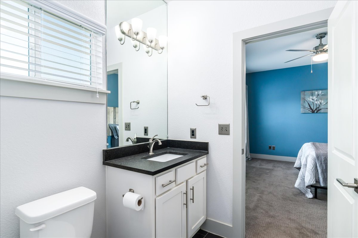 2021 Local Rebel Street, Unit 2021 Leander, TX 78641 - Photo 27 of 40 Ensuite bathroom featuring vanity, dark carpet, a chandelier, and ceiling fan