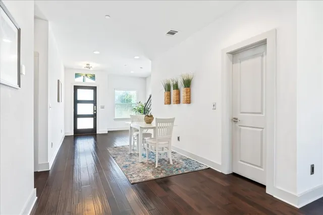 a view of a livingroom with wooden floor and furniture