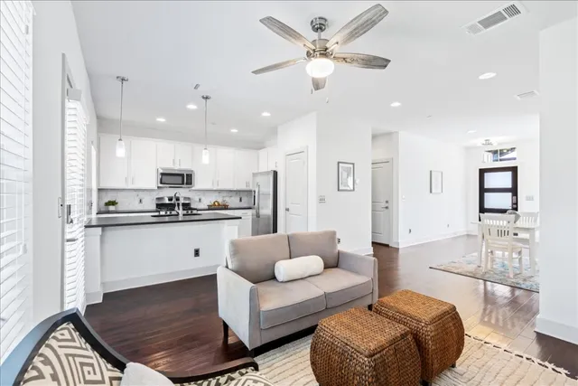 a living room with furniture kitchen view and a chandelier